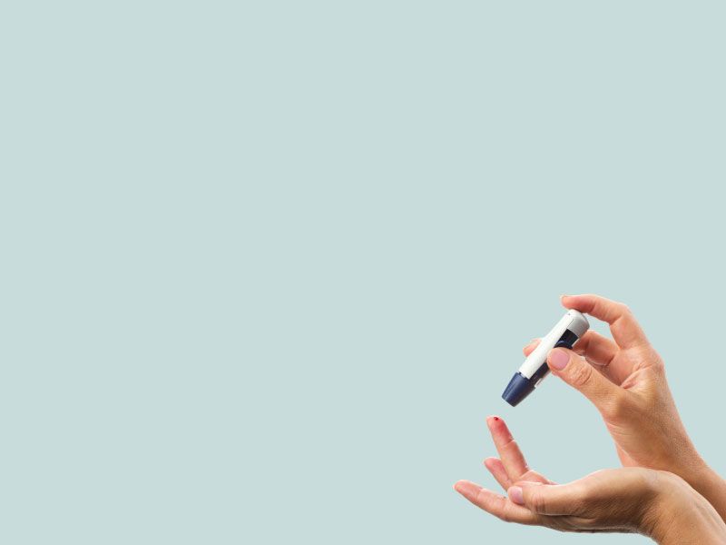 A person is using a lancet to prick their finger for a blood test