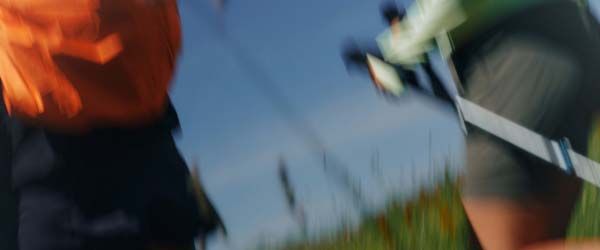 A woman and man running through a field with motion blur