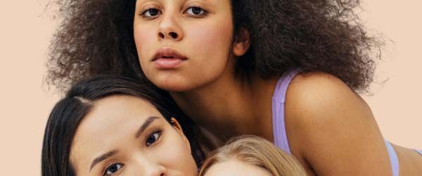 3 women with neutral expressions with a cream background