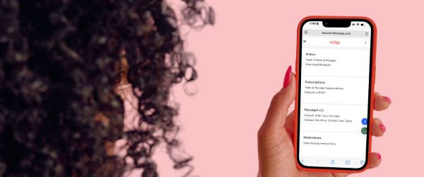 A woman holding a mobile phone with Wisp's account page on the screen
