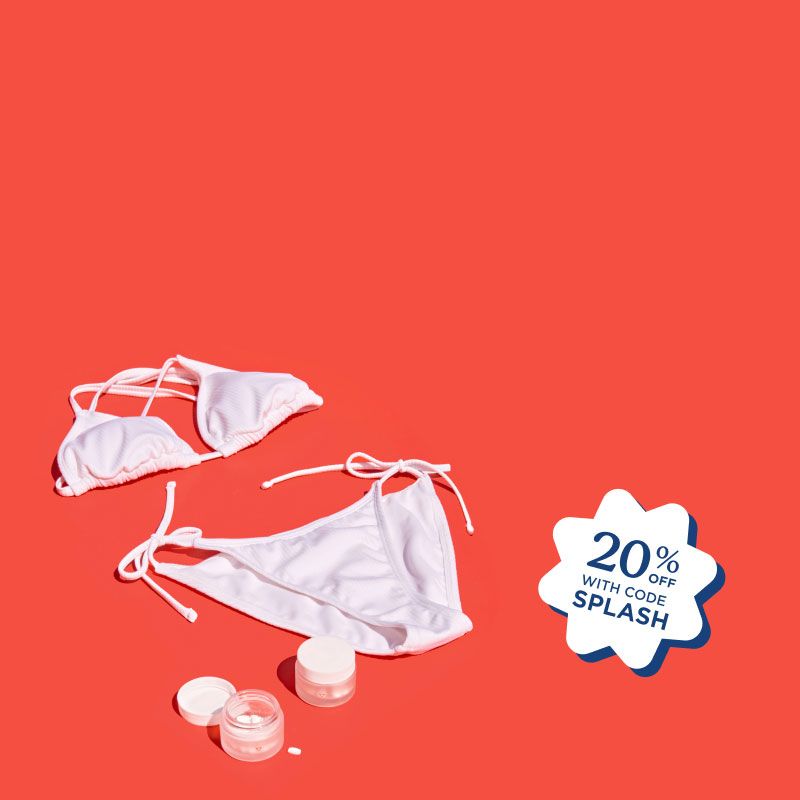 A white bikini, striped towels, and Wisp medications sitting on a red surface next to a pool