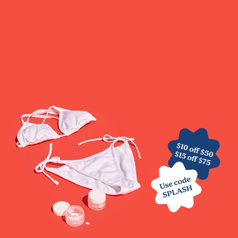 A white bikini, striped towels, and Wisp medications sitting on a red surface next to a pool