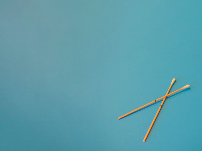 Orange test swabs on a teal-colored background