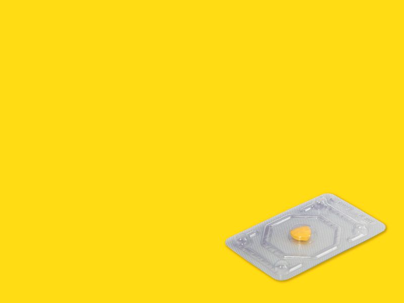 An emergency contraception packet laying on a yellow surface