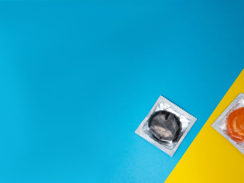 A purple and and orange condom on a blue and yellow surface