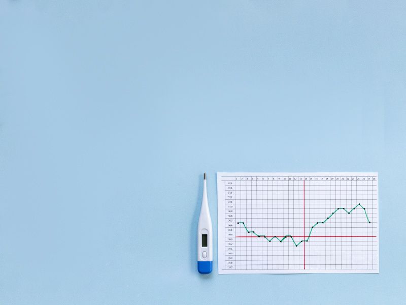 A thermometer and a diagram tracking temperature changes on a light blue background