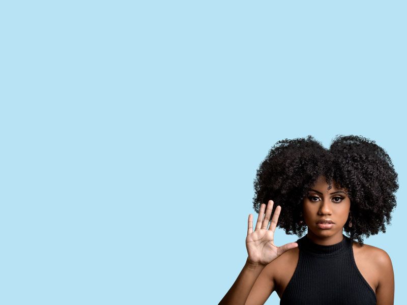 a woman holding up her hand in a stop motion against a blue background