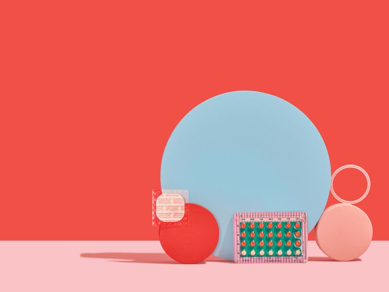 Birth control pills, birth control patch, and vaginal birth control ring placed on and against red, blue, and pink circles with red and pink background