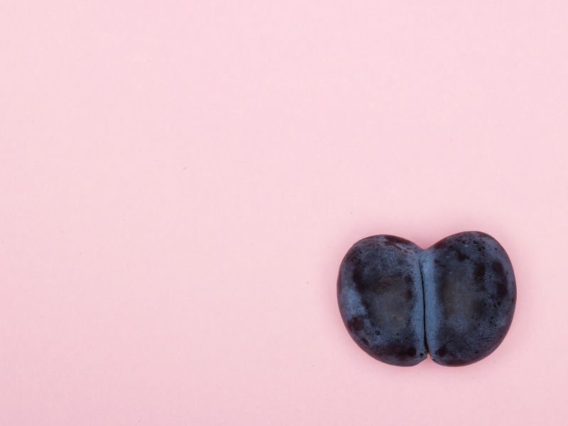 A cut open fruit on a pink background