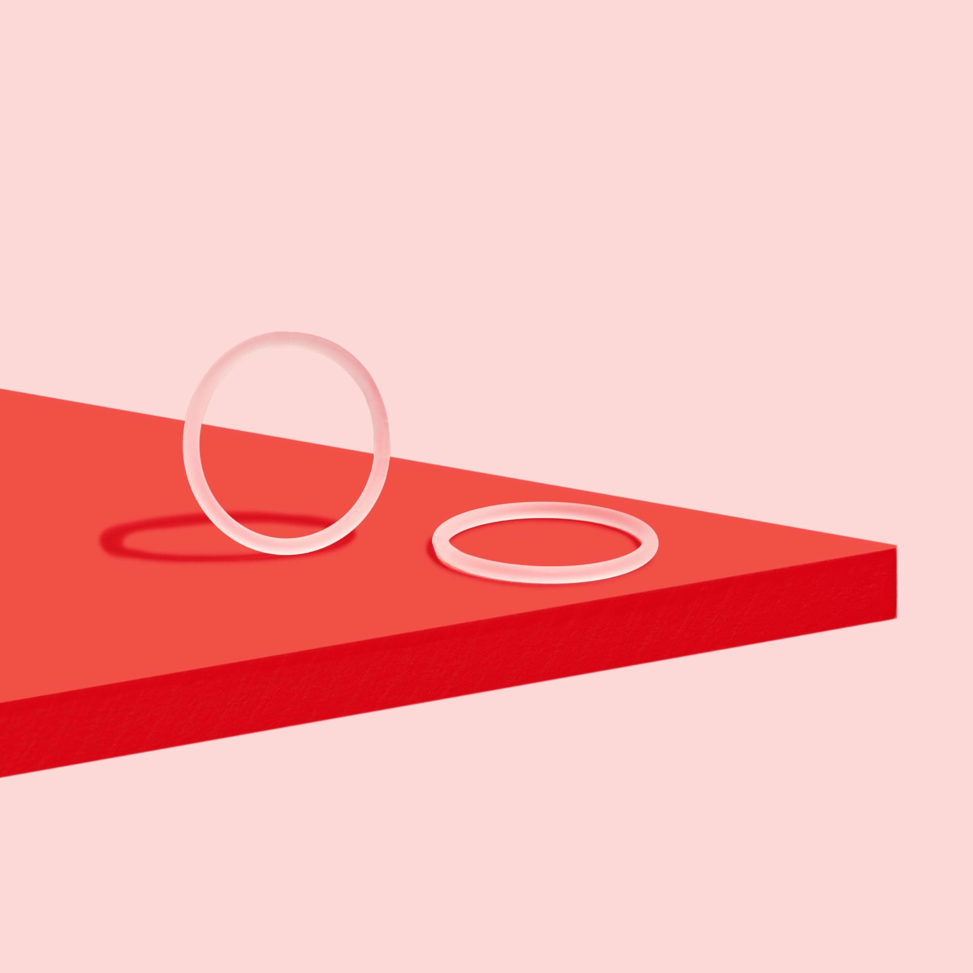 NuvaRing birth control on a red surface with a pink background