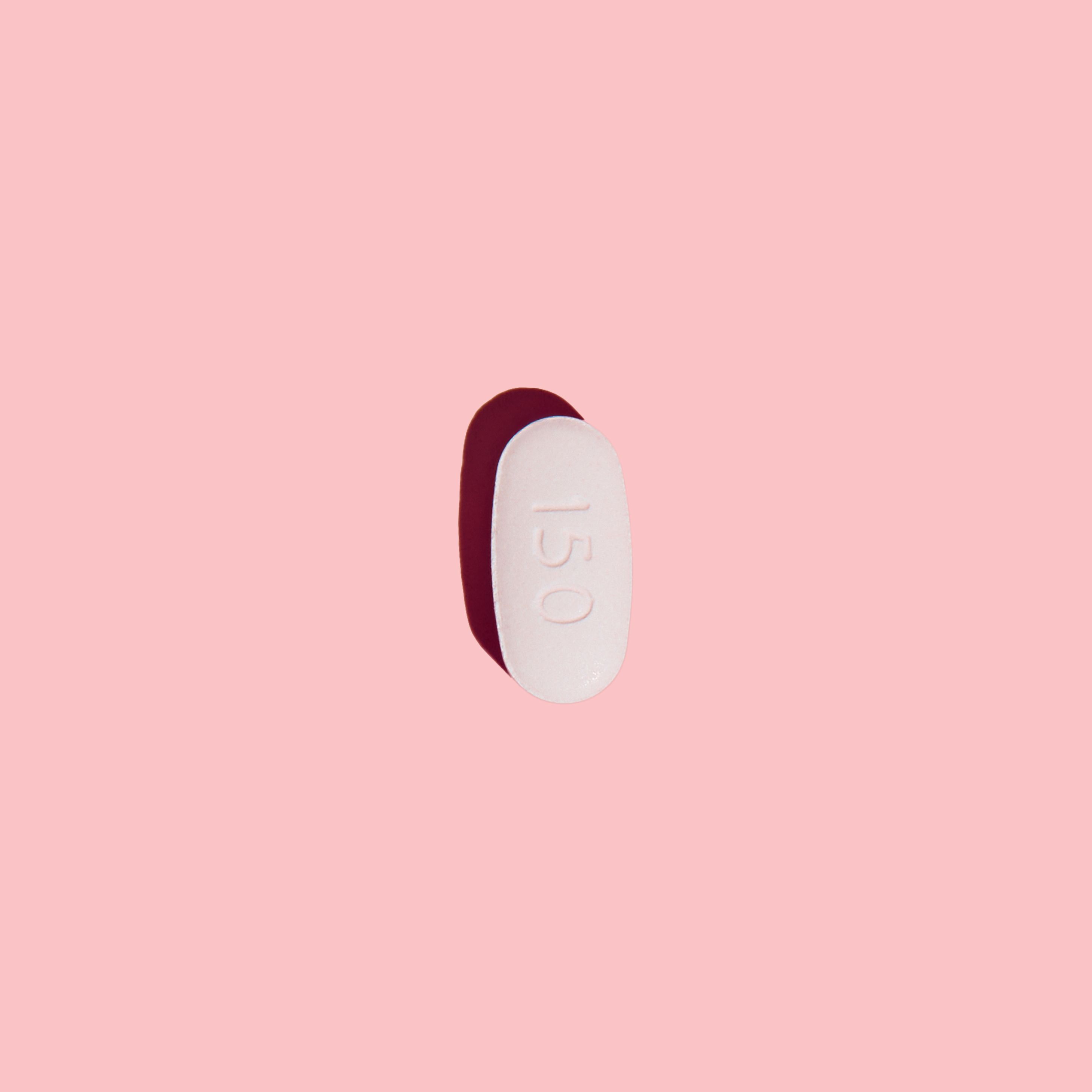 Antifungal pill to treat yeast infections on a pink surface