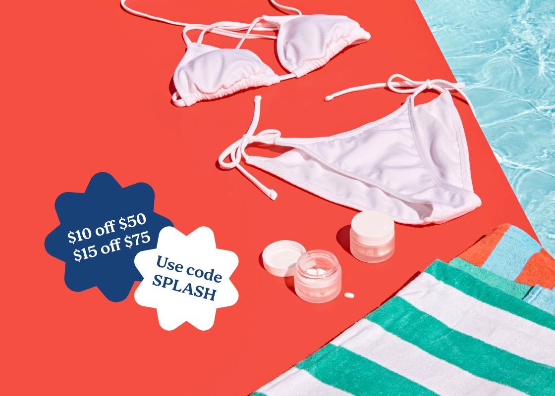 A white bikini, striped towels, and Wisp medications sitting on a red surface next to a pool