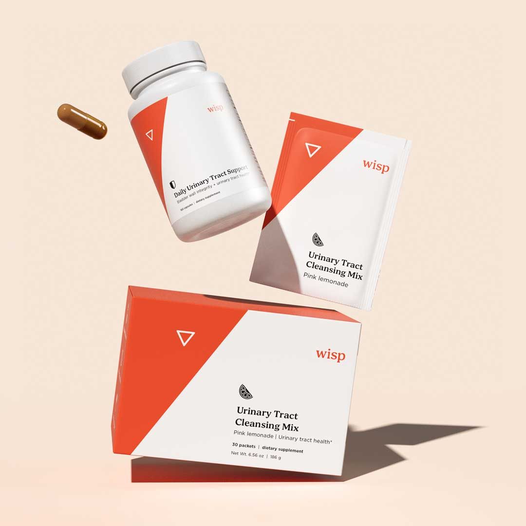 Wisp Urinary Tract Cleansing Mix and Daily Capsules on a cream surface