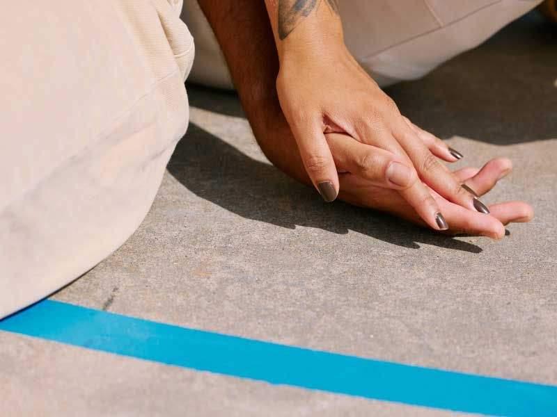 Close up of two people holding hands on a concrete surface