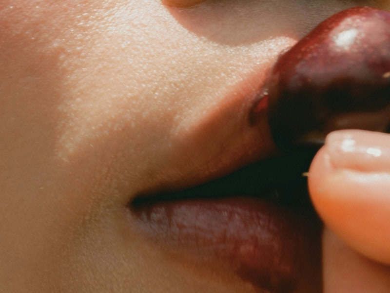 image of woman's lips on a cherry