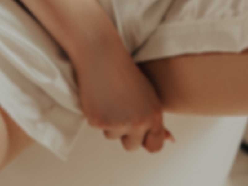 Close up of a person adjusting the crotch of their white shorts