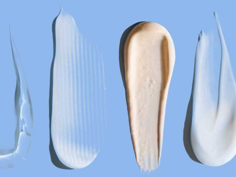 Assorted skincare product swatches on blue background.