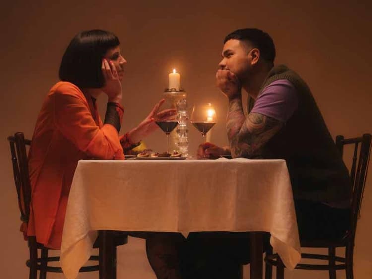 A coupld having and intimate candlelight dinner with wine