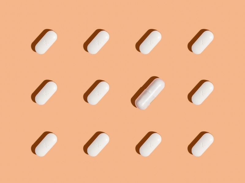 orange background with a mixture of white pills and capsules