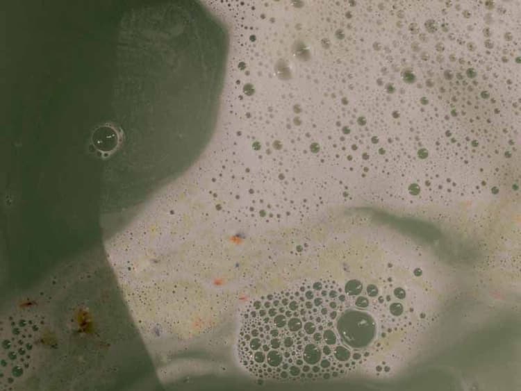 Green-tinted water with foamy suds