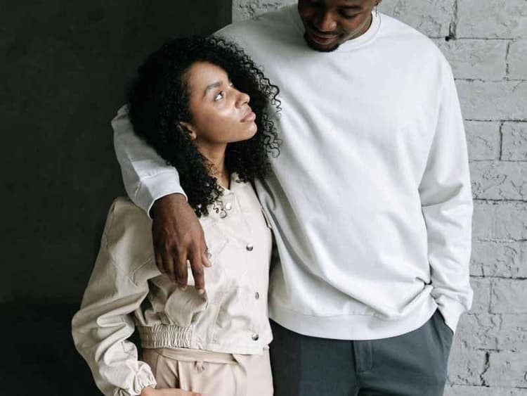 A man with his arm around a woman and they appear to be having a conversation