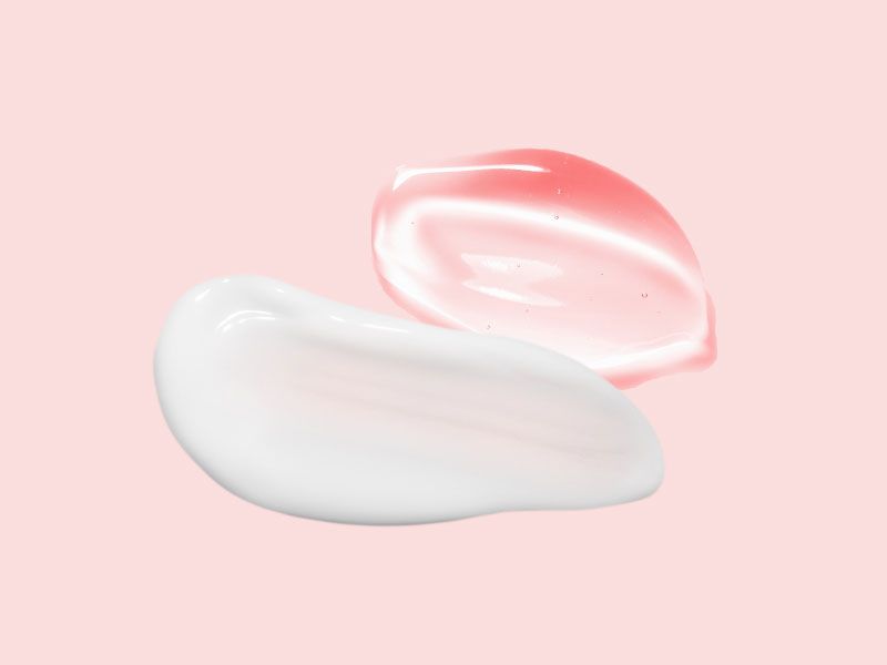 A white cream swatch and a clear gel swatch on a pink surface