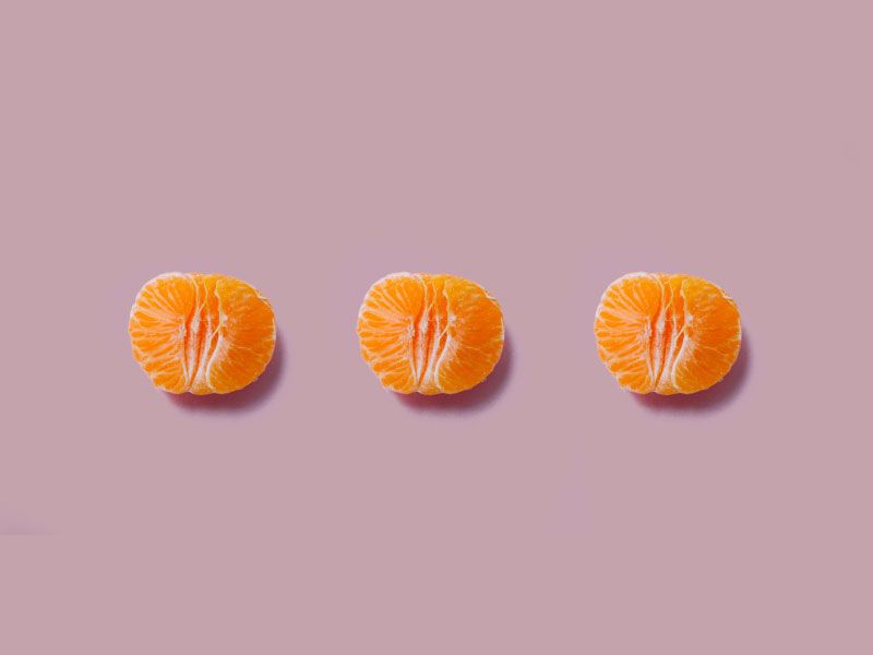 3 halved oranges on a mauve background