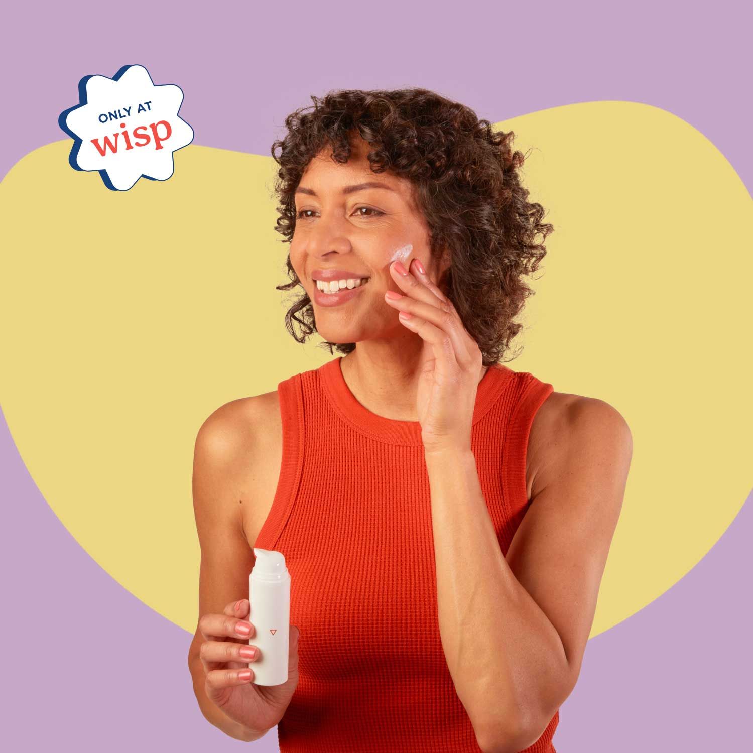 A woman smiling and wearing a red tank top is applying Topical Spironolactone on her face