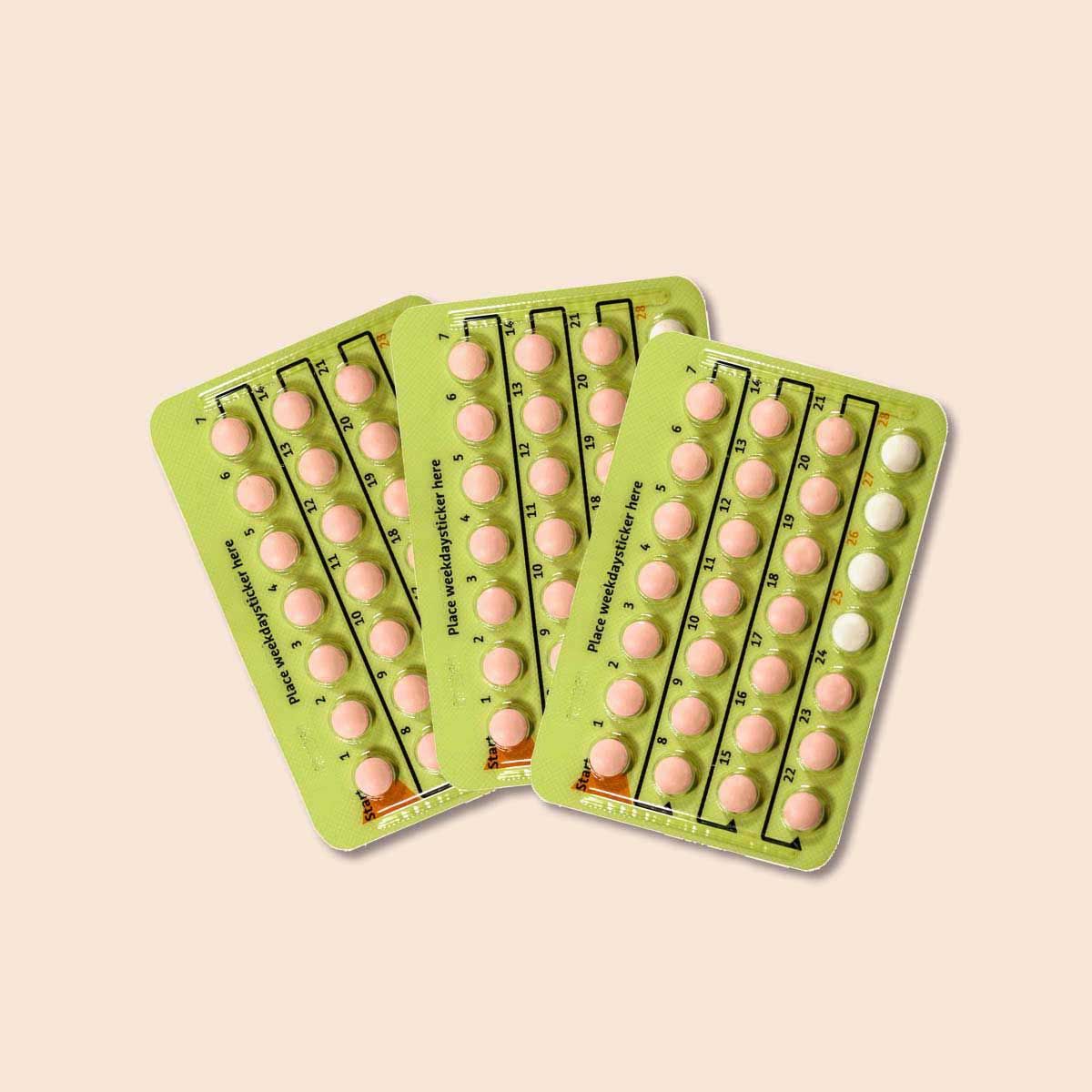 Packets of Sprintec birth control pills on a cream background