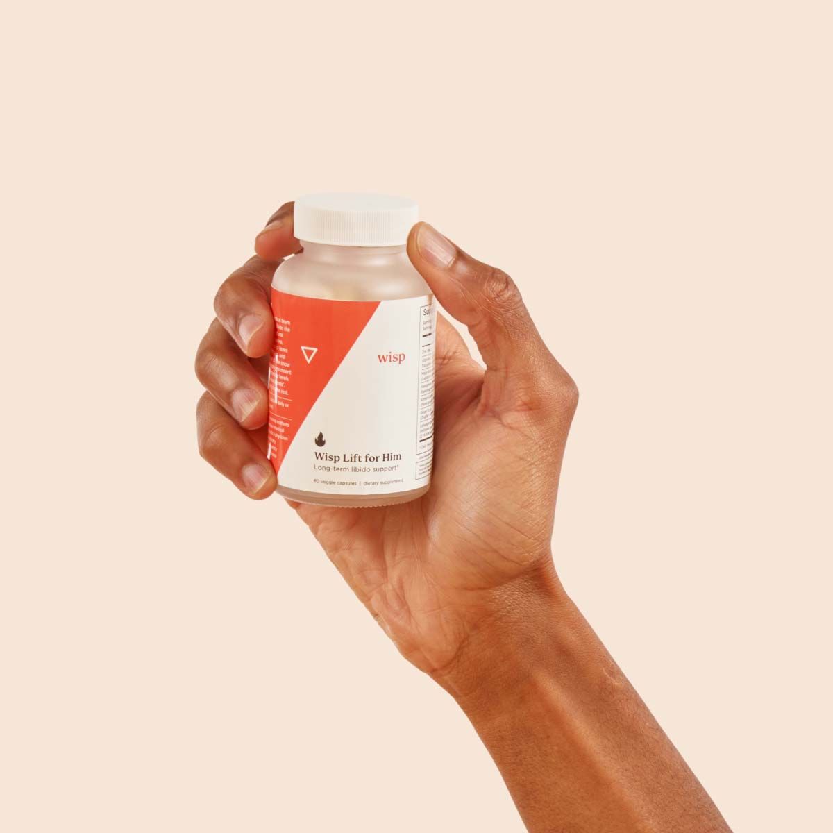 Wisp Lift Libido Supplements for Him in a person's hand with a cream background