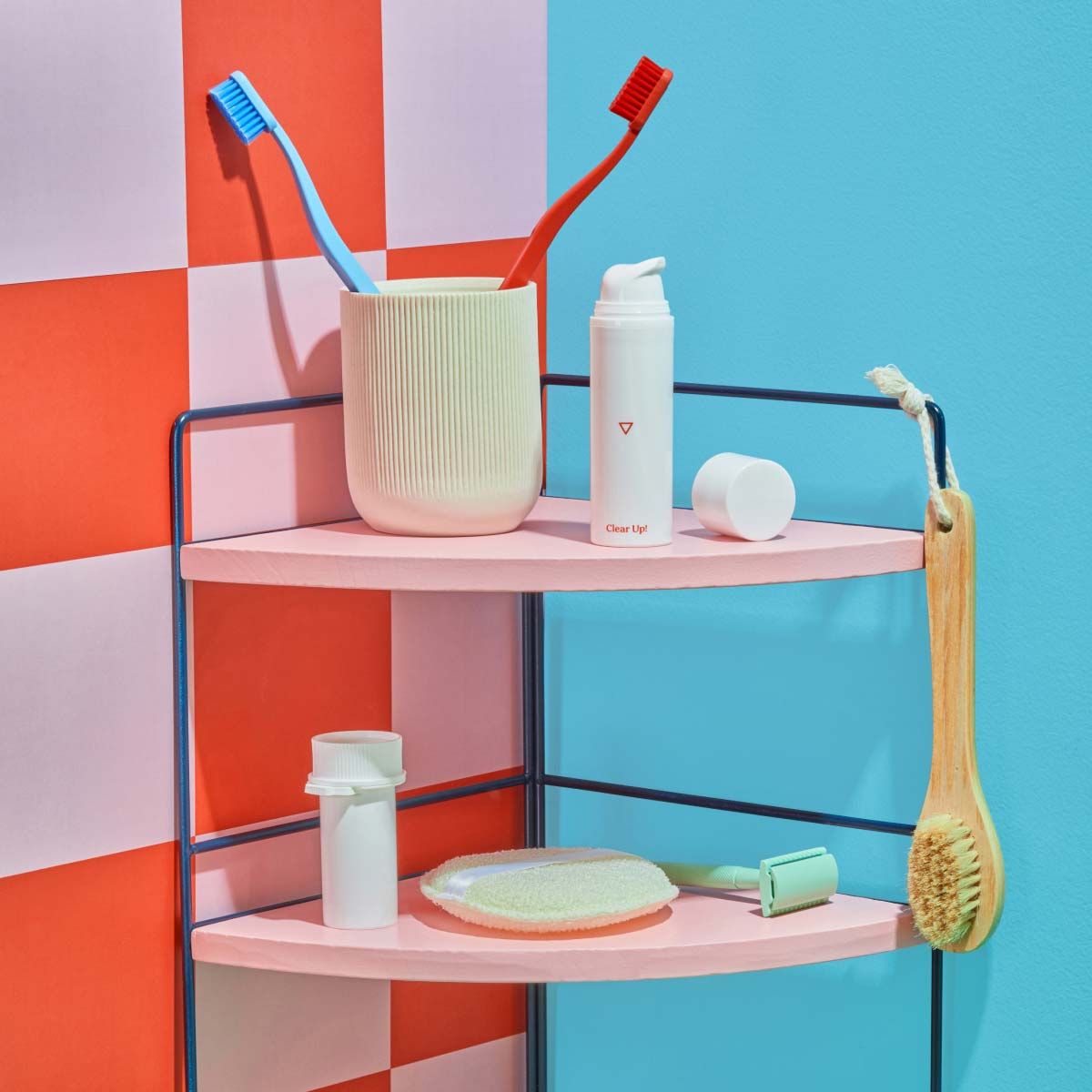 A pink bathroom cart with a green toothbrush holder and colorful toothbrushes, various Wisp products and bath accessories on it