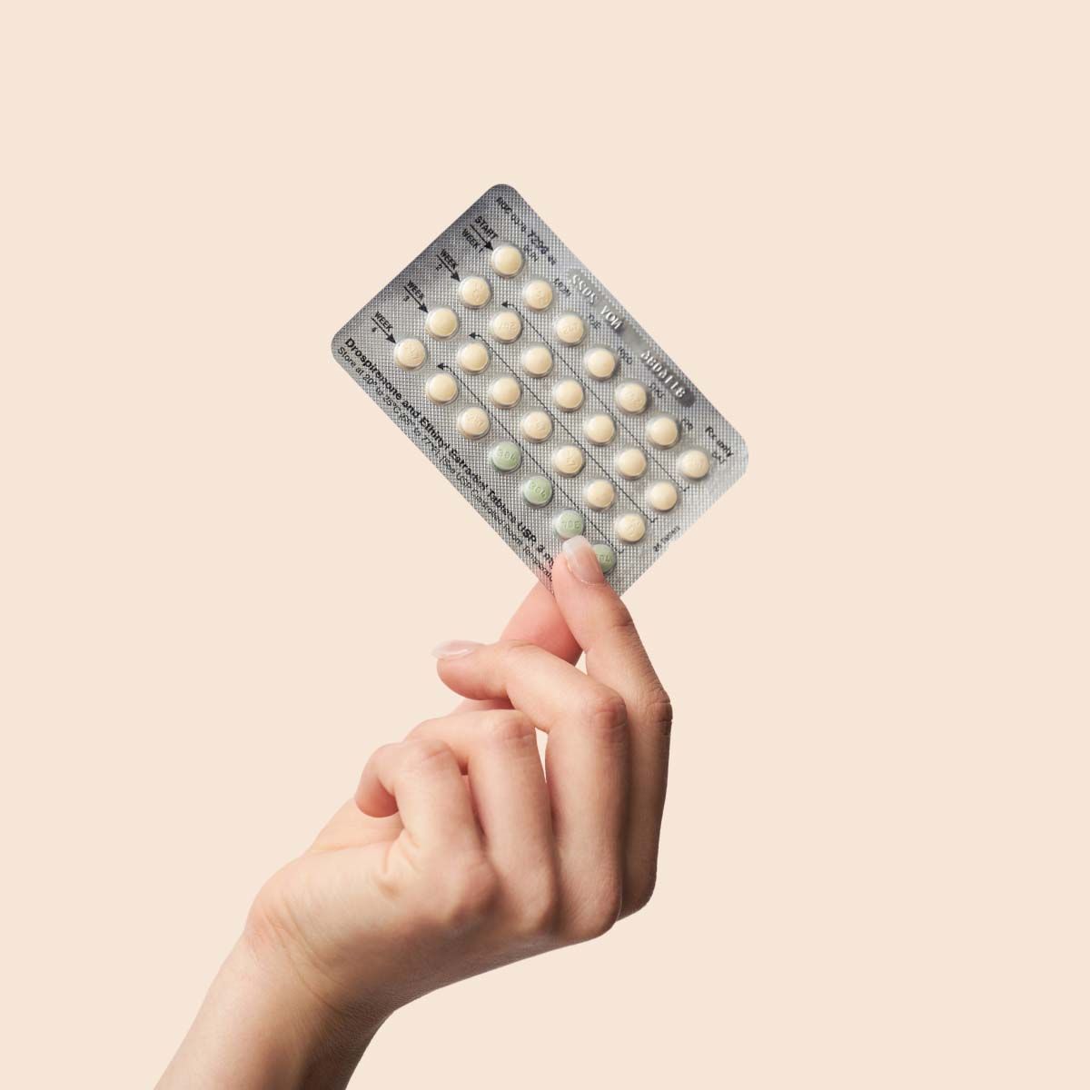 Packet of birth control pills on a cream background