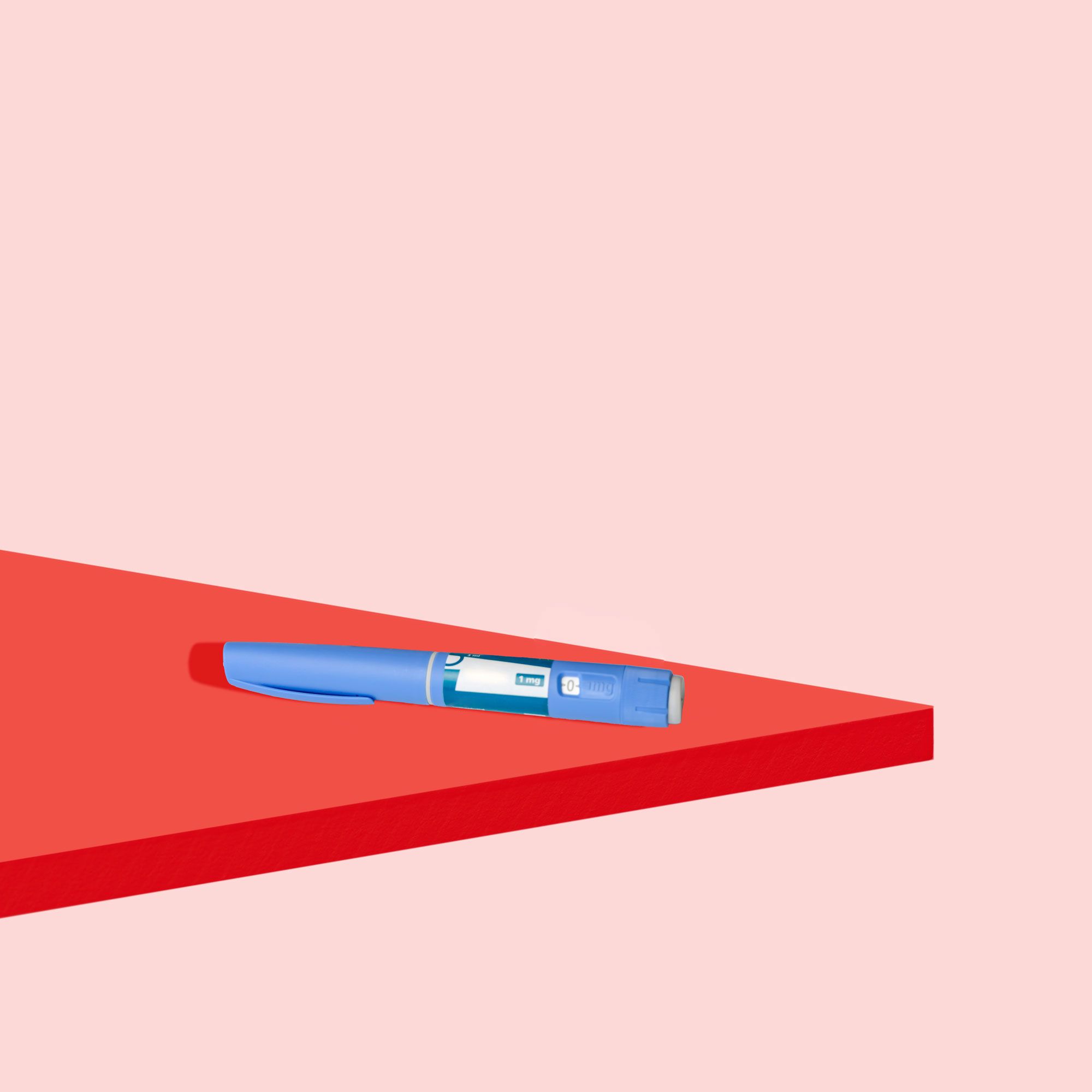 Saxenda injectable on a red geometric background with a pink background