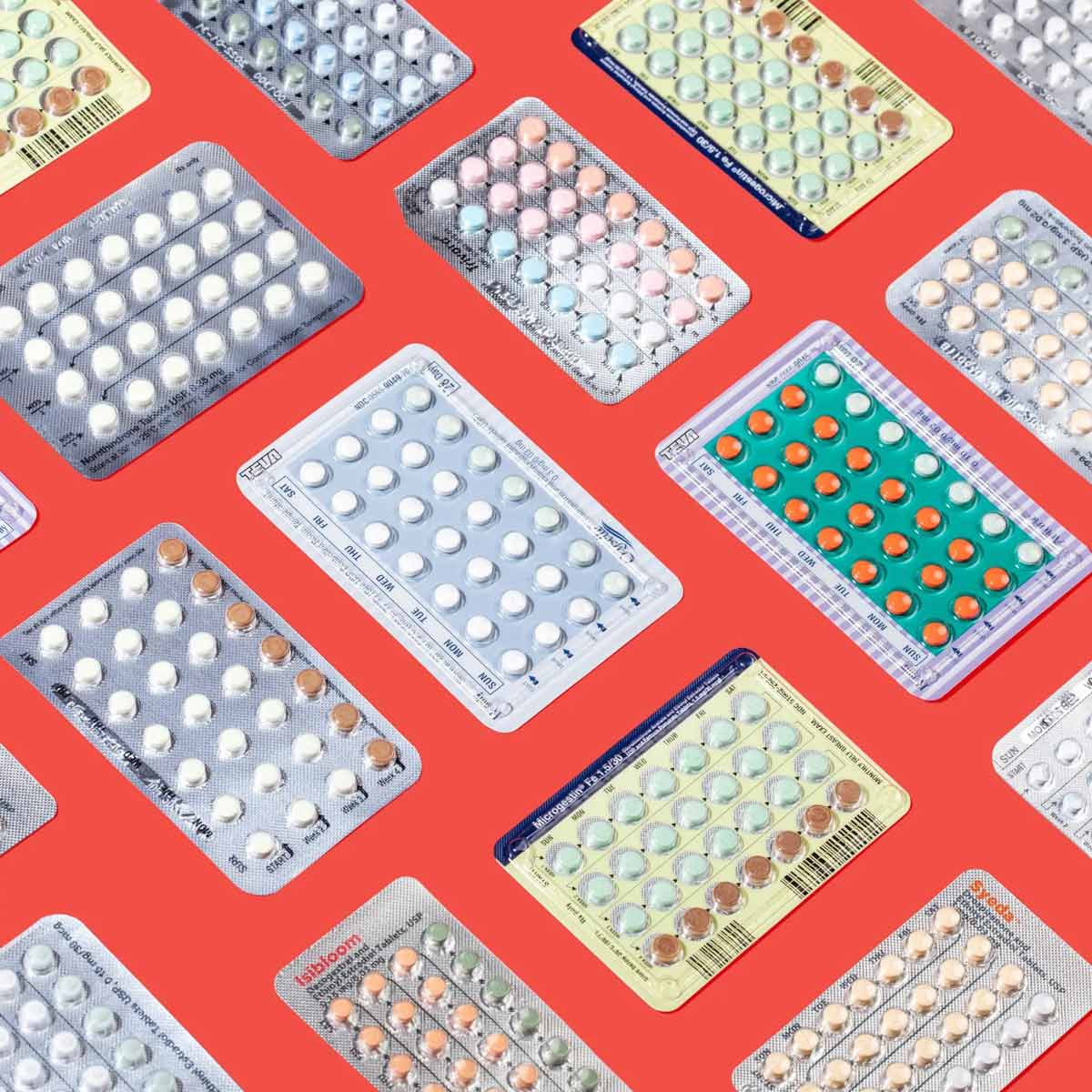 Several colorful birth control packets on red background