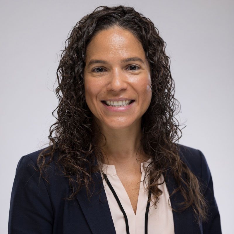 Jennifer Peña, MD, FACP, AAHIVS wearing white button up shirt and a black jacket