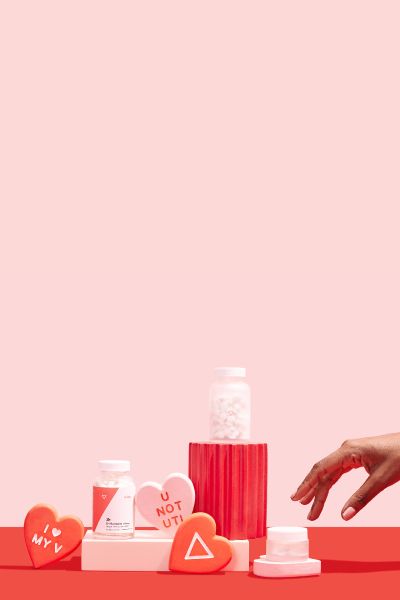 A woman's hand reaches for Wisp products and V-Day hearts on a pink and red background