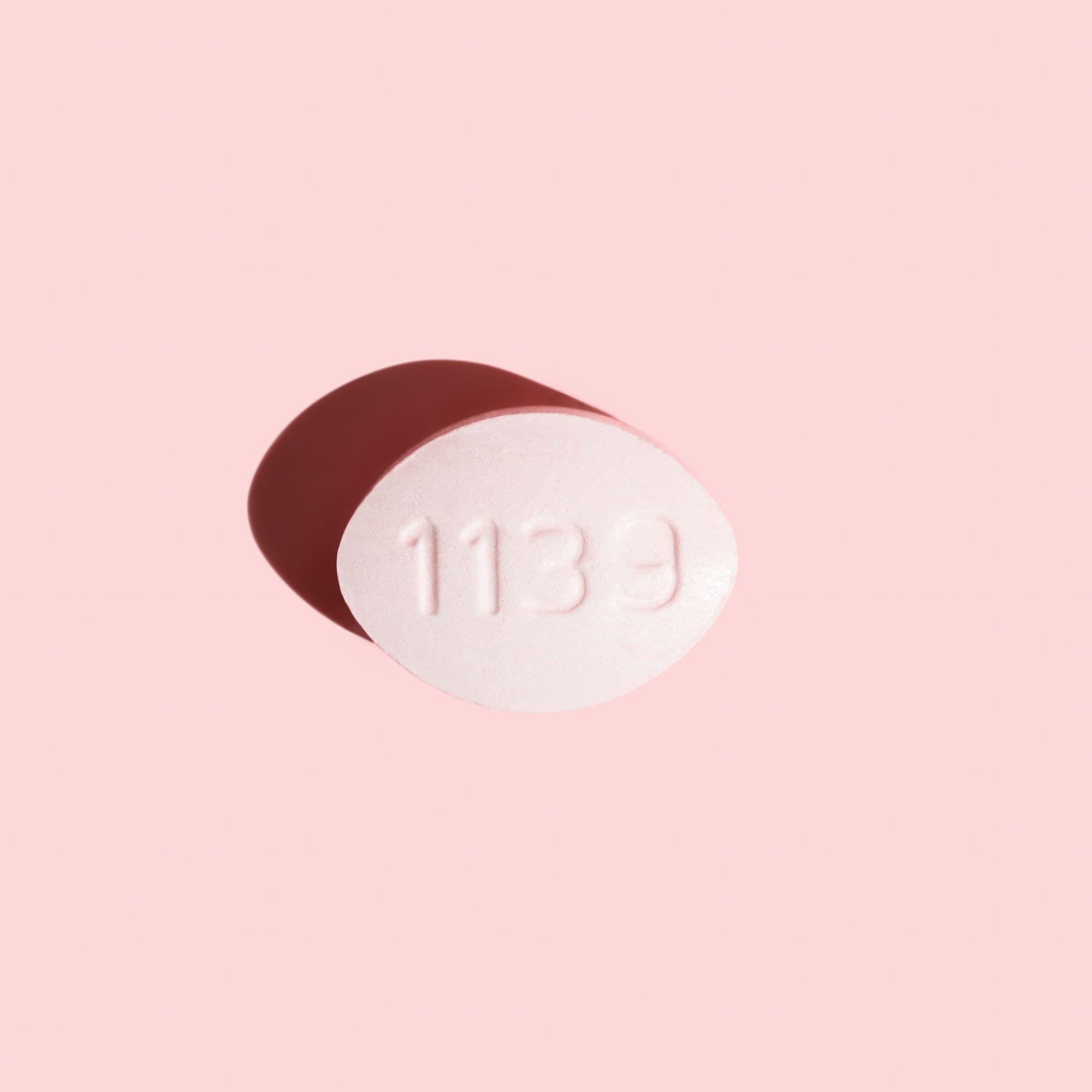 Antifungal pill to treat yeast infections on a pink background