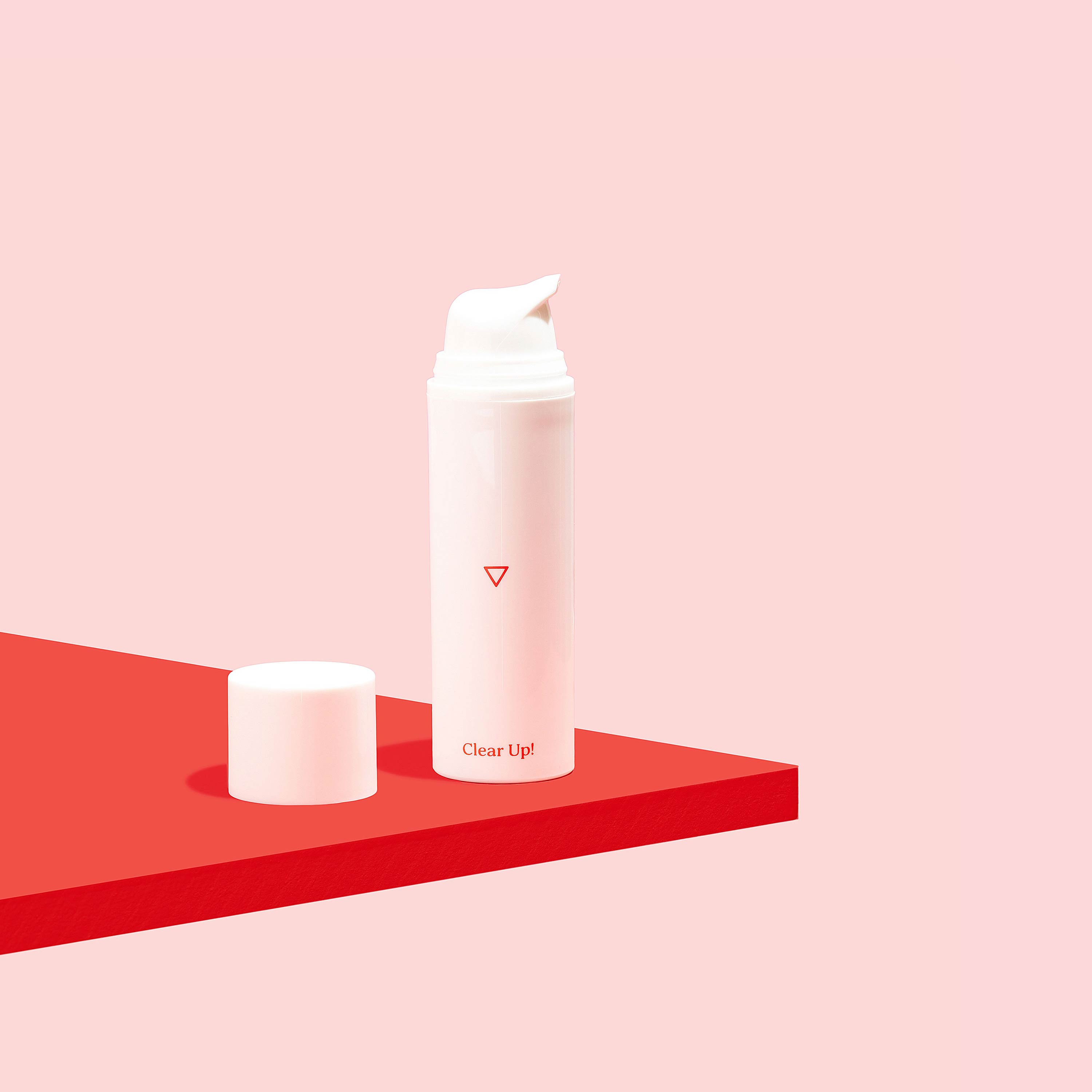 Clear Up! Acne Cream on a red surface, on a pink background