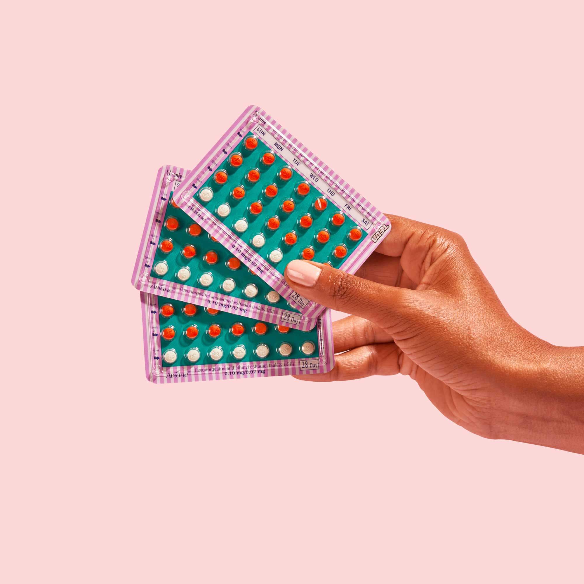 Woman holding colorful birth control packets 