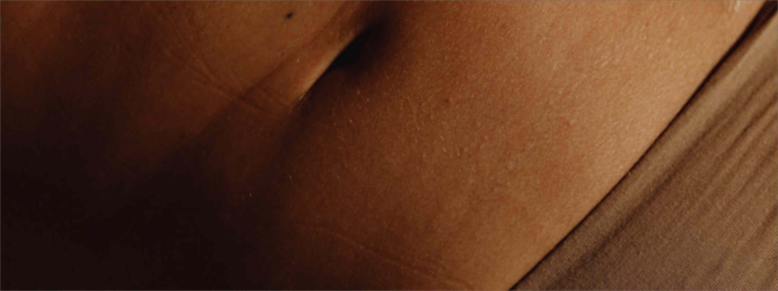 Close-up of skin in warm lighting, representing the body changes associated with hyperthyroidism and weight gain.
