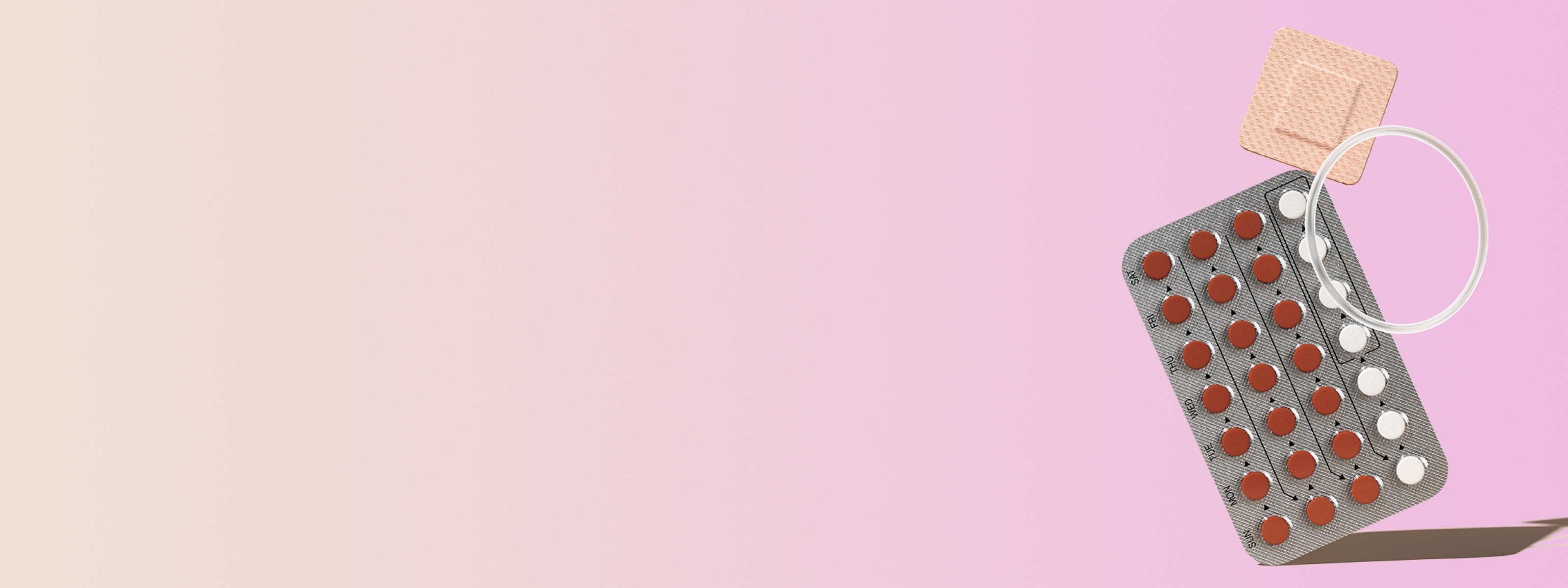 various birth controls in front of a light pink background