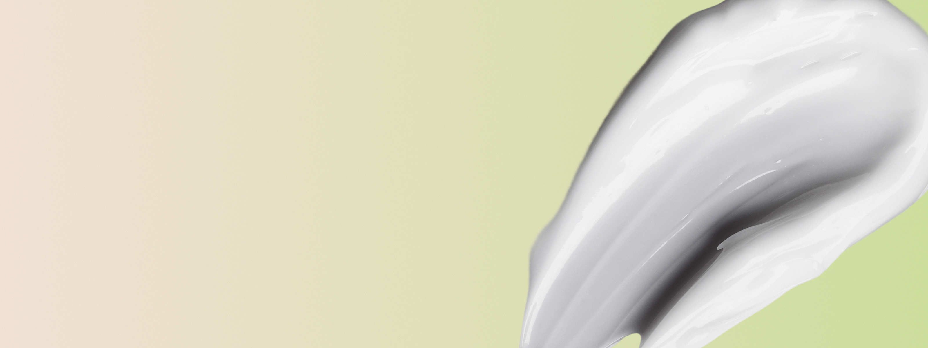 swipe of tretinoin cream in front of a light green background