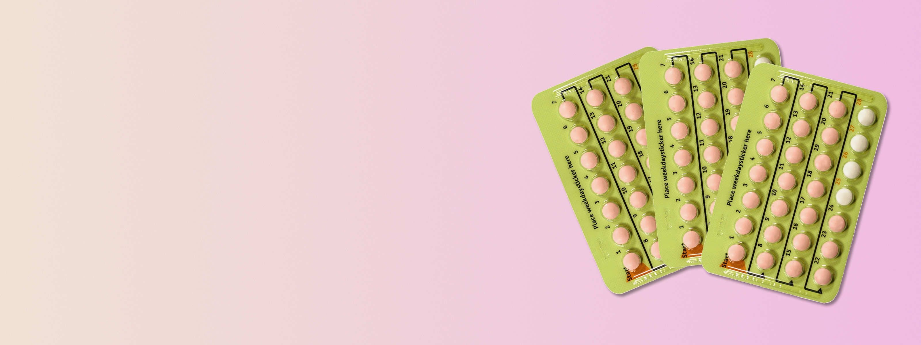 three yellow birth control packs in front of a pink background