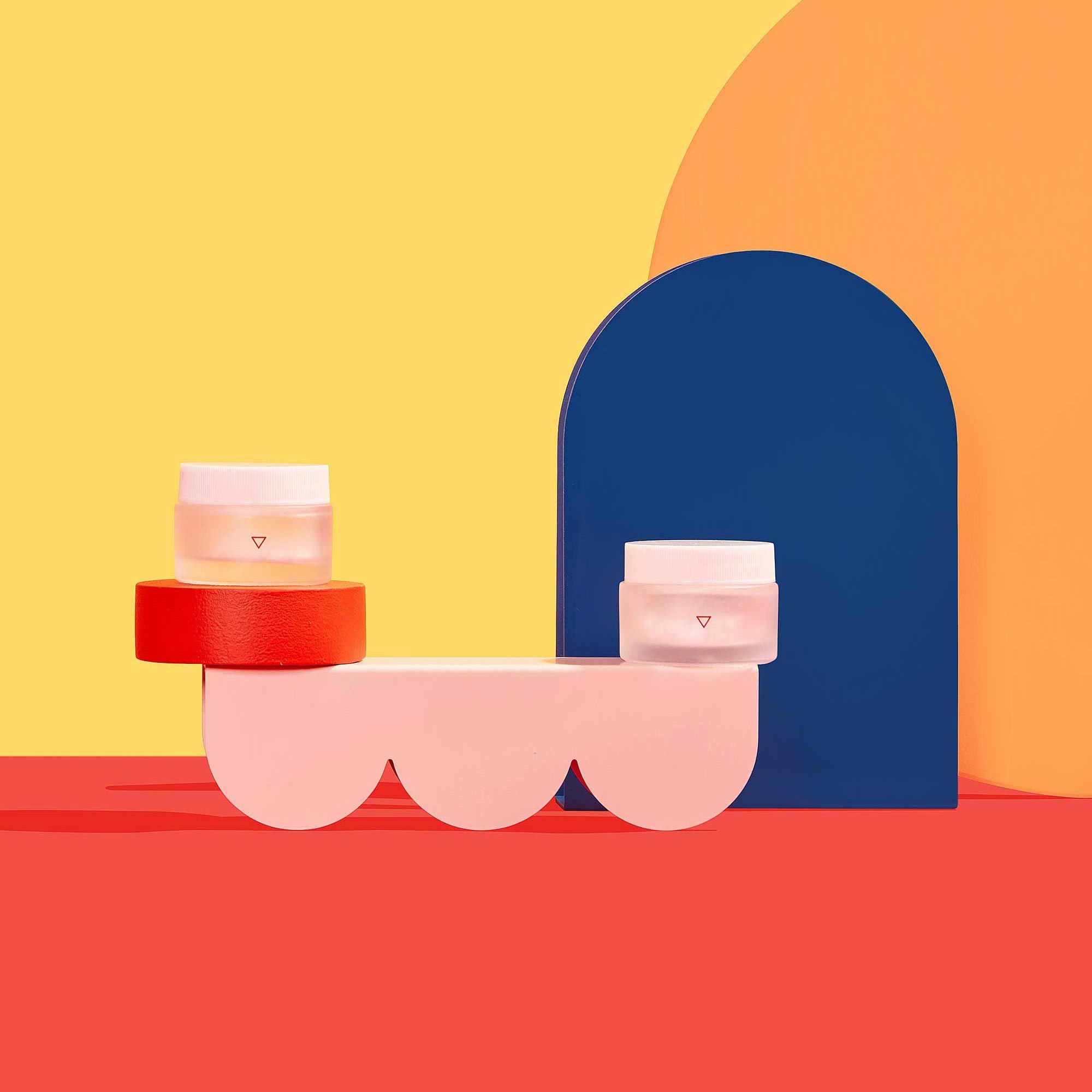 pill bottles on red and yellow background with colorful geometric shapes