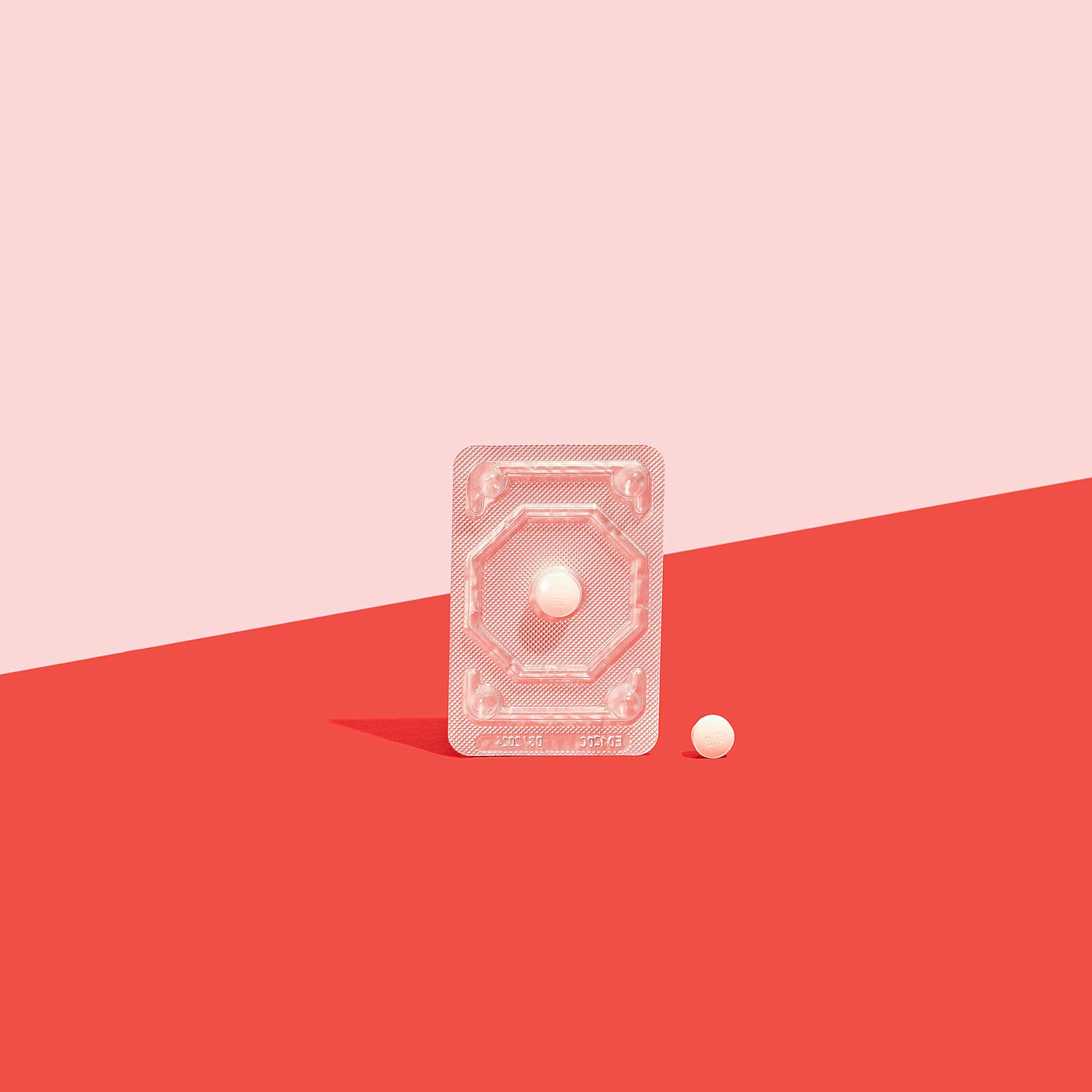 Ella emergency contraception in foil packet to prevent pregnancy on a red surface, on a pink background