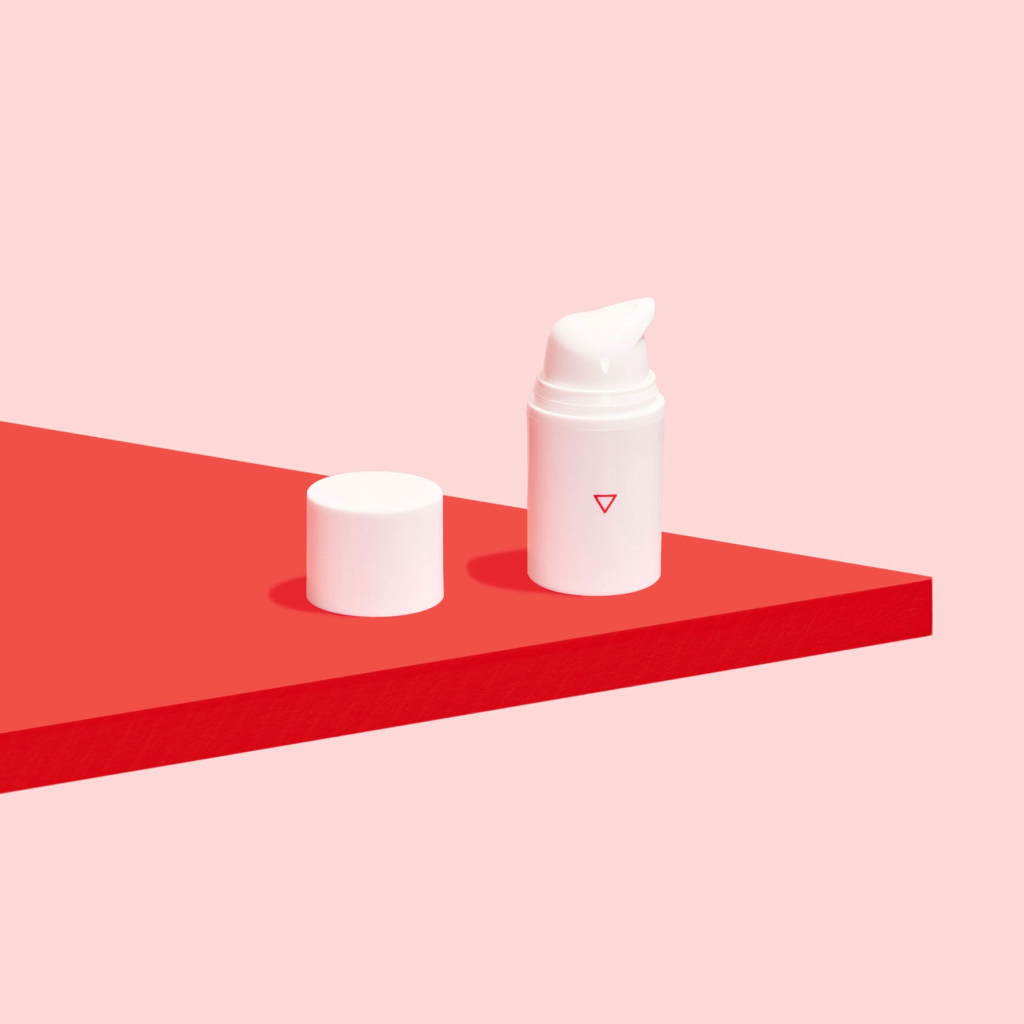 Bottle of Estradiol cream on pink background and red surface