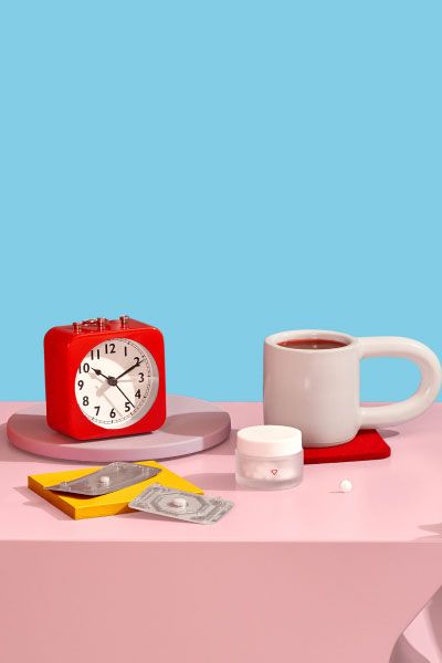 Emergency contraception and reproductive health medication sits on nightstand next to coffee and alarm clock