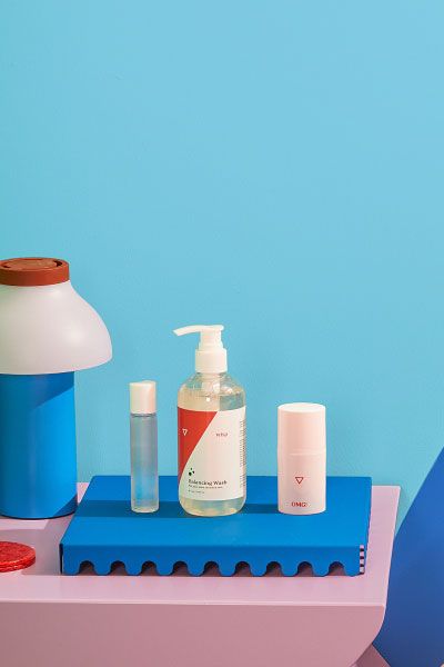 Wisp's Better Sex products on a nightstand with a lamp, colorful abstract shapes and a blue and green background