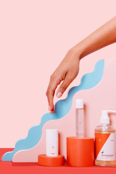 Wisp Intimate Care products with colorful abstract shapes on a pink and red background