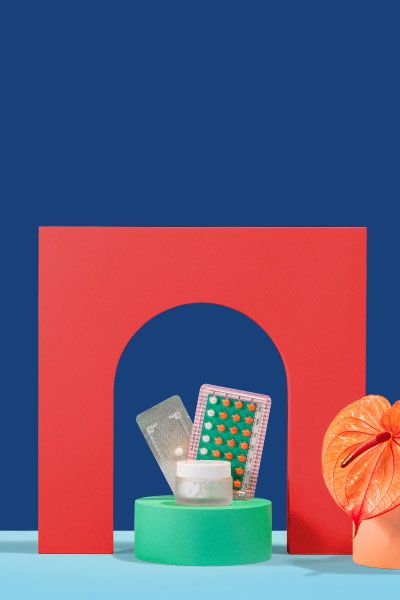 Birth control, emergency contraception, and Delay Your Period medications sitting next to flower on colorful geometric background